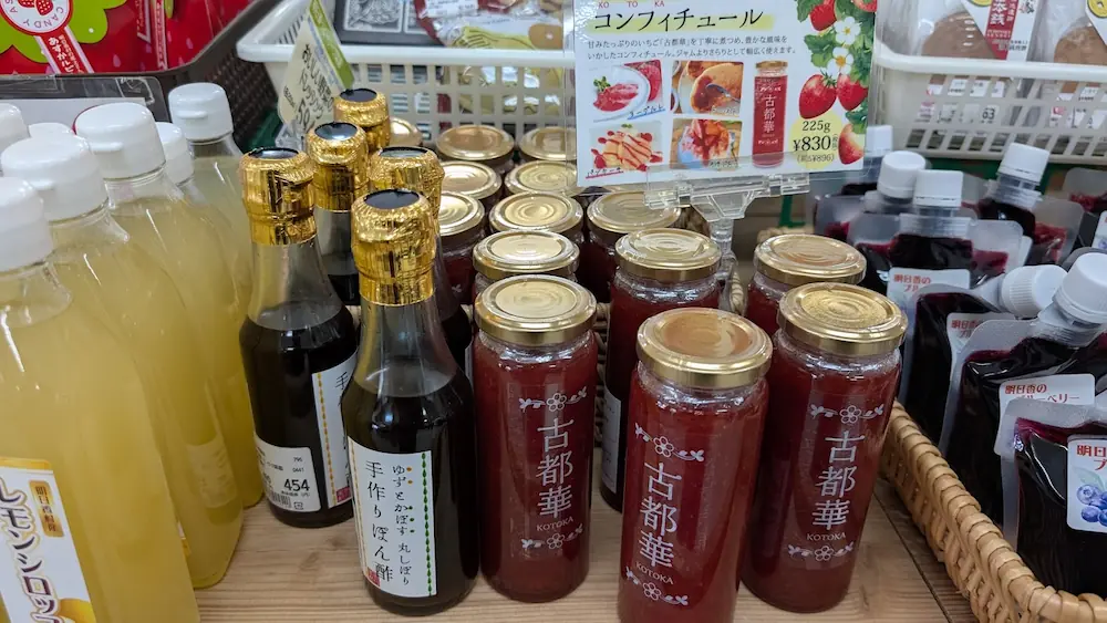 明日香村の特産いちご「古都華」を使用したコンフィチュール(ジャム)。瓶詰めにされた色鮮やかな赤いジャムと、ヨーグルトやトーストへの活用例を紹介する商品ポップ。