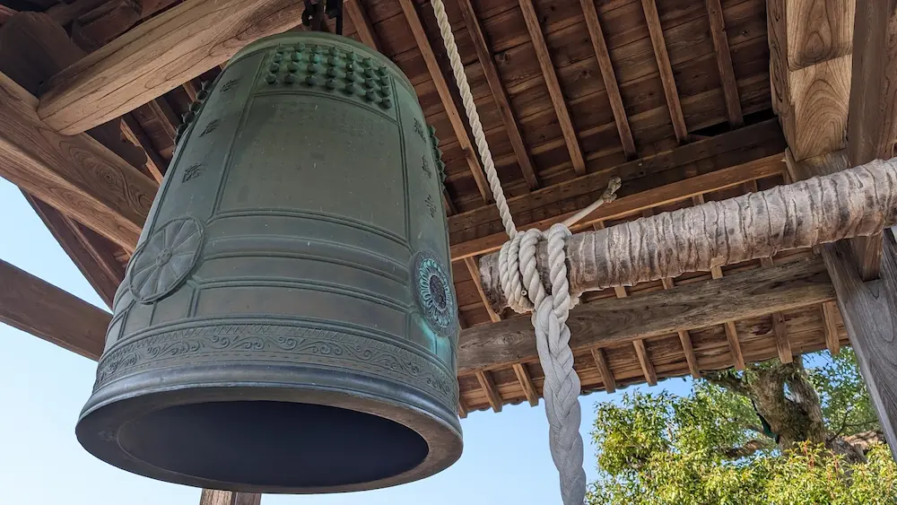 明日香村にある飛鳥寺の鐘楼。緑青が美しい大きな梵鐘と、それを打ち鳴らすための太い撞木(しゅもく)が吊り下げられている様子。