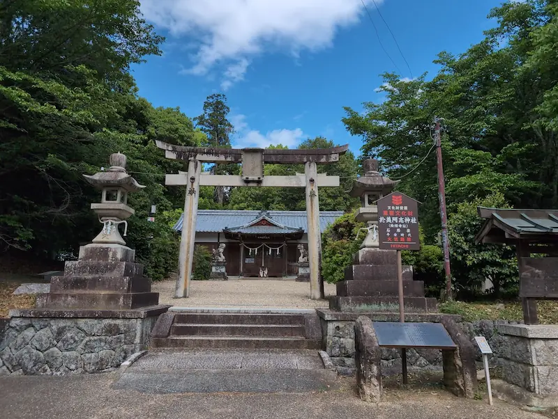 於美阿志神社（檜隈寺跡）の入り口にある石造りの鳥居と両脇の灯籠。奥に拝殿が見える。