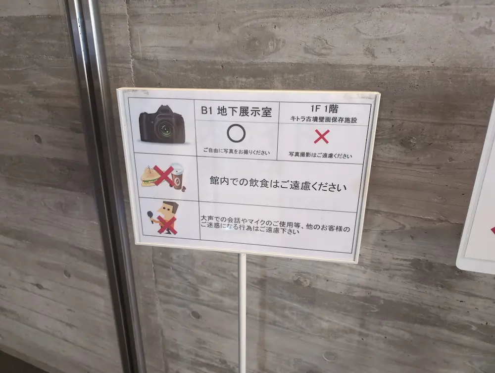 四神の館における撮影・飲食禁止等のルール案内板。「B1地下展示室は撮影OK、1Fキトラ古墳壁画保存施設は撮影NG」と明記されている。
