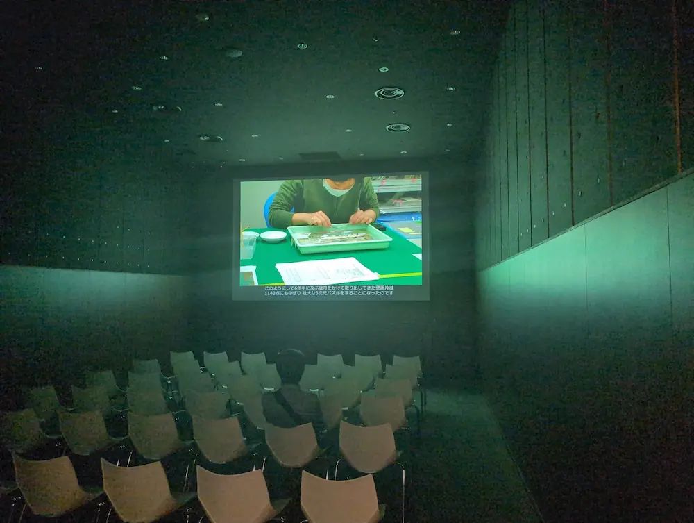 四神の館シアタールームの様子。壁画の修復作業を記録した映像がスクリーンに投影されている。