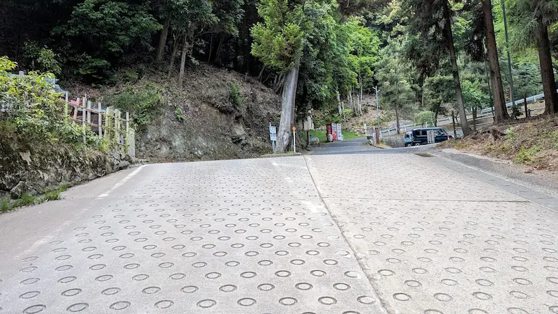 松尾寺駐車場手前のアクセス路。中央に木が立っており、道幅が狭く運転に注意が必要な場所。