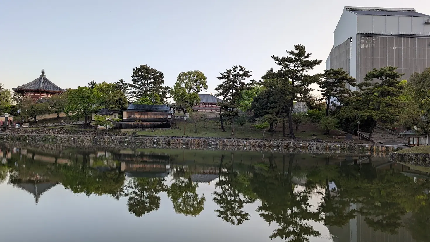 奈良市の猿沢池。早朝の静かな水面に、修理用の素屋根に覆われた興福寺五重塔のシルエットが鏡のように反射している風景