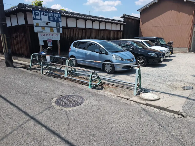 お房観音のすぐ横にある、5台分の無料駐車場の様子。地面は舗装されておらず砂利になっており、周囲の道や駐車スペースが狭いことがジンバル撮影の画角から確認できる。