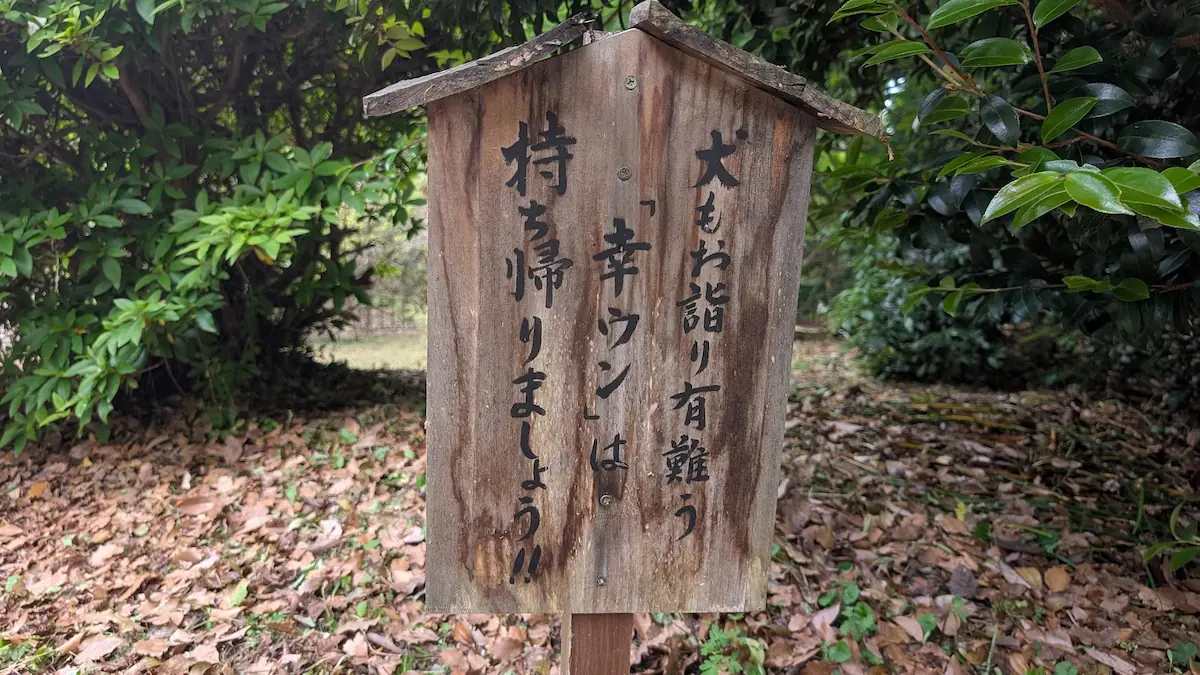 於美阿志神社の境内に設置された、犬のフン持ち帰りを呼びかける「幸ウン(幸運)」の文字が書かれた木製の面白看板。