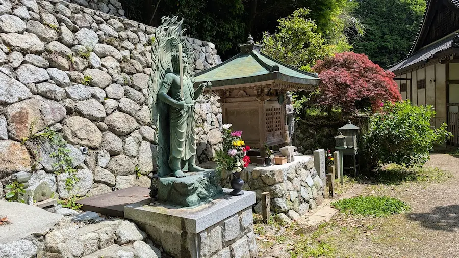 船宿寺の「しゃくなげの森」の道中にある聖域。手前に不動明王、中央に小さな祠、奥に観音菩薩の石像が並び、周囲は豊かな緑に囲まれている