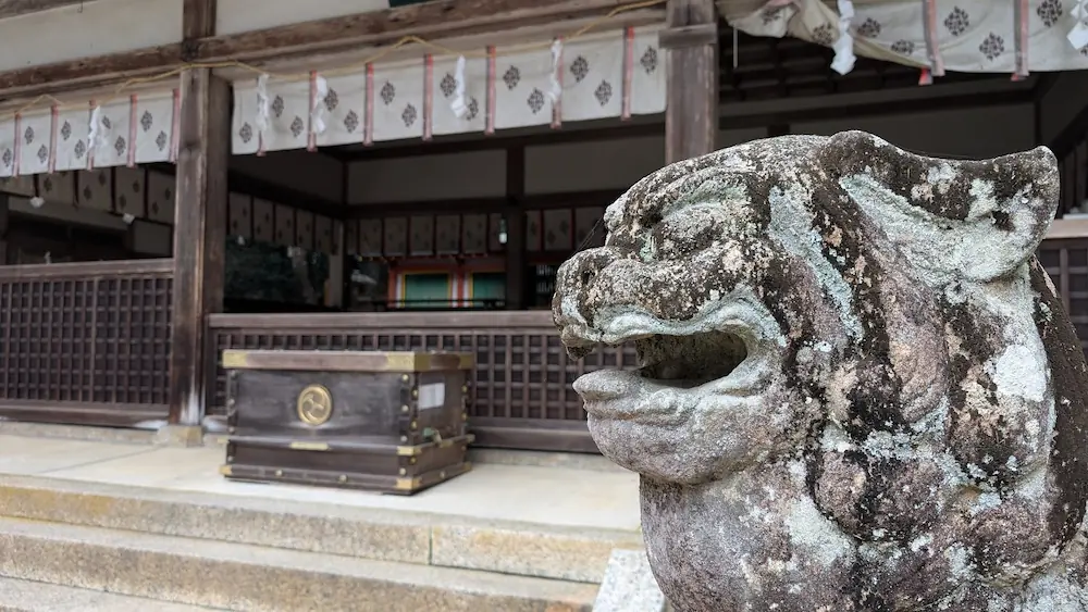 都祁水分神社の拝殿前に鎮座する、石造りの狛犬（吽形）のアップ。長い年月を経て苔が生え、味わい深い表情をしている