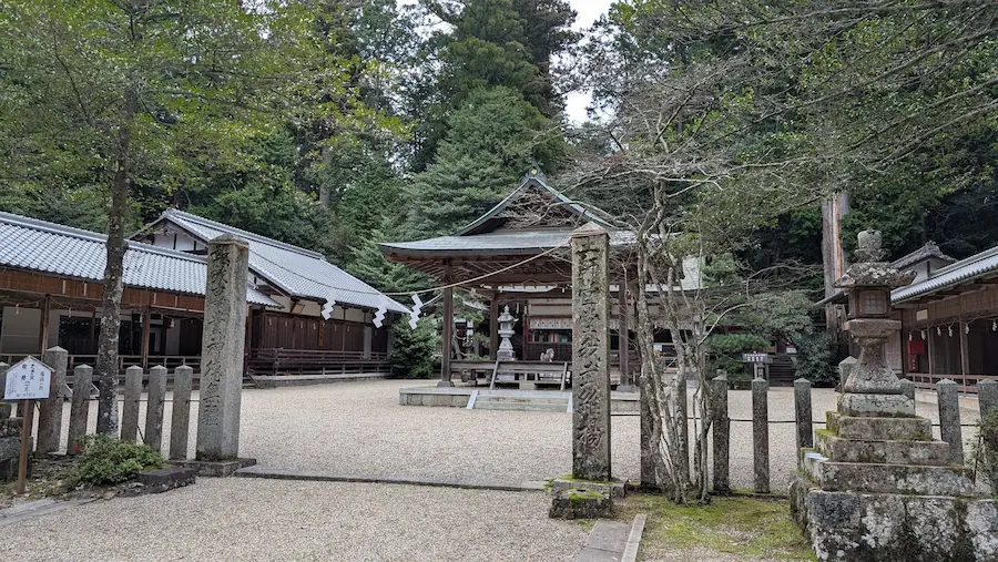 都祁水分神社の境内全景。手前には美しく整えられた砂利が広がり、中央に拝殿、左手には社務所などの建物が並んでいる。周囲は高い木々に囲まれている風景