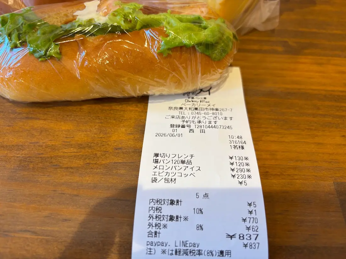 ベーカリーメイで購入したパンと、その合計金額が記載されたレシート。各商品の価格と支払方法が示されている。