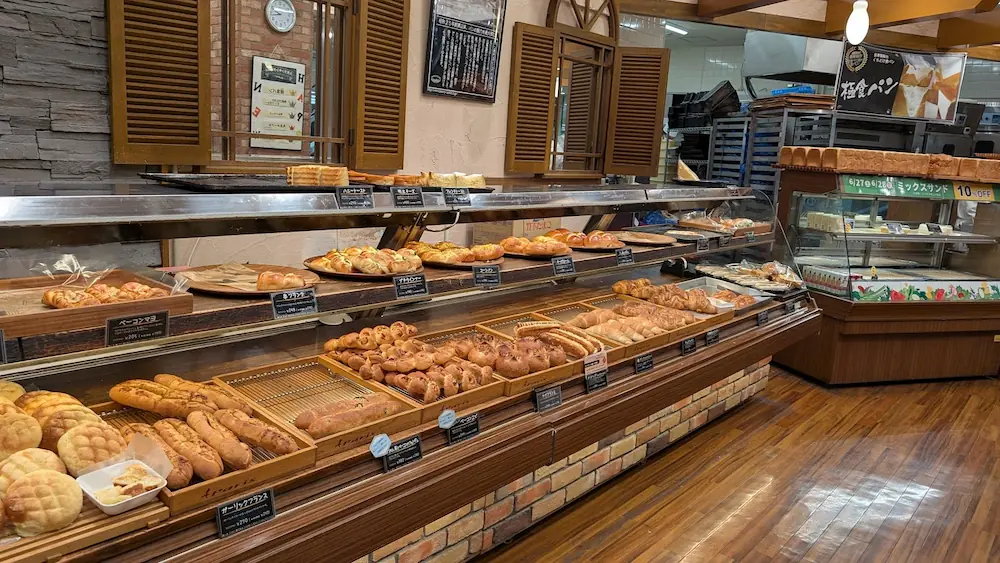 キャパトル真美ヶ丘店の店内に並ぶ焼きたてパン。メロンパンやフランスパン、惣菜パンなど、多様な種類のパンが陳列された売り場の様子