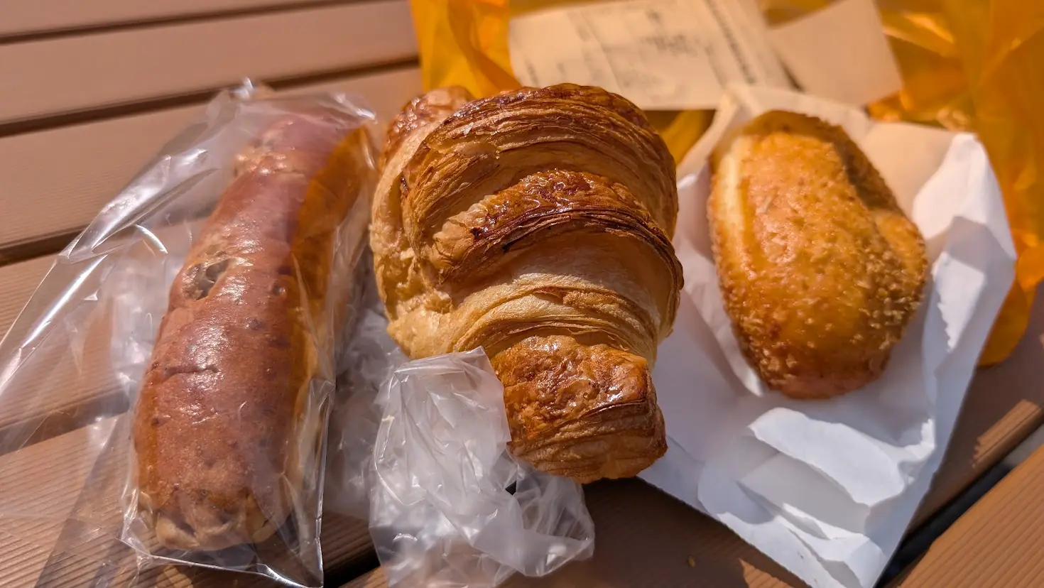 キャパトル真美ヶ丘店で購入したパン。左から「くるみクリームパン」、中央に「クロワッサン」、右に看板商品「熟成ゴロゴロビーフカレー」が並ぶ様子