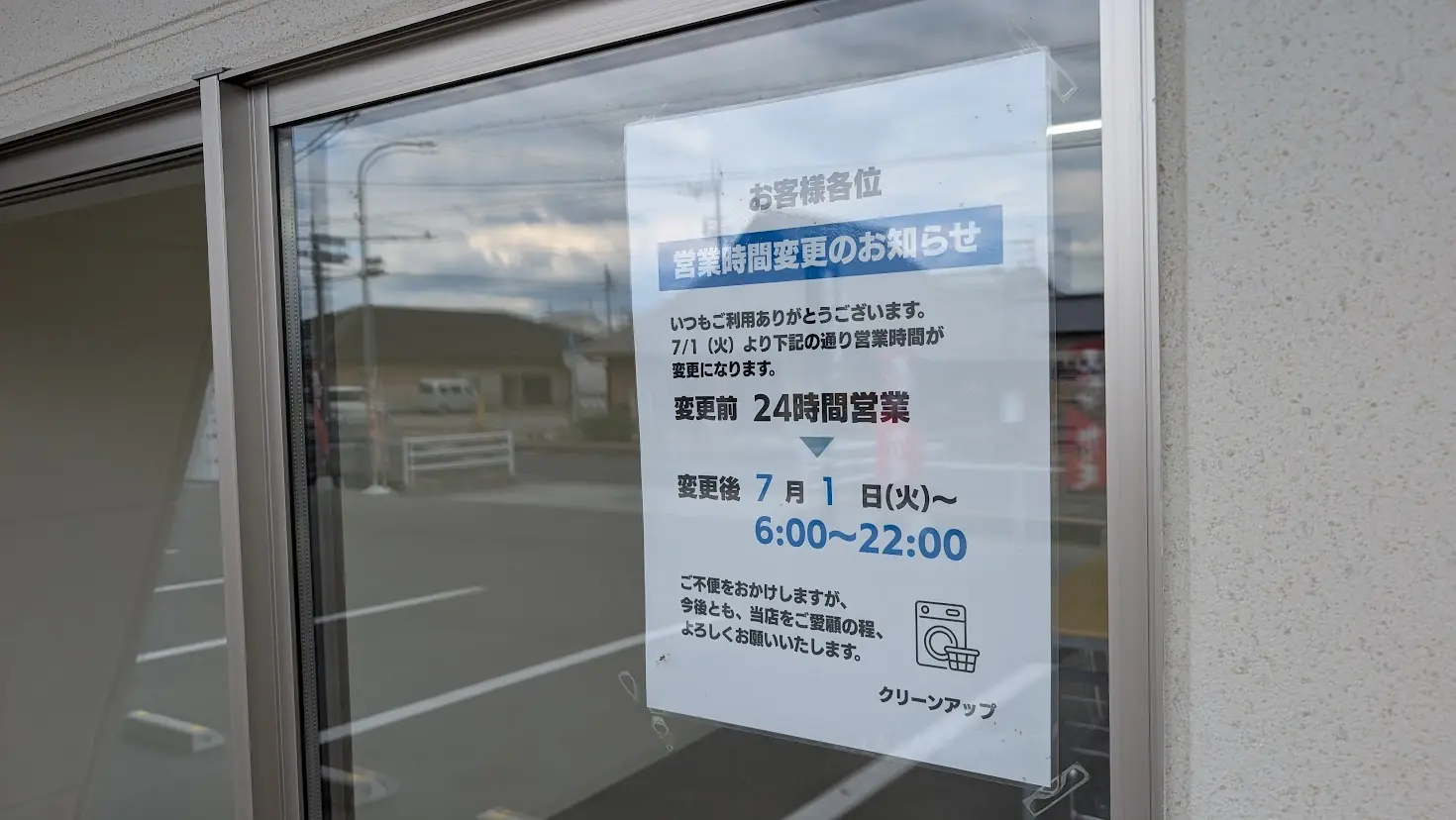 「コインランドリー クリーンアップ」の店舗窓に掲示された、営業時間変更を伝えるお知らせ。7月1日（火）より6:00〜22:00に変更となる旨が記載されている
