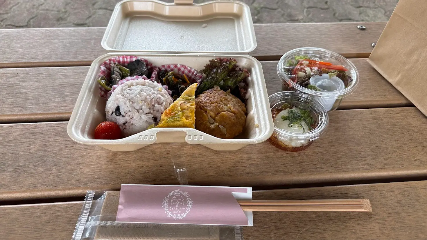 広陵町の「大仏カフェ」でテイクアウトした「大仏御膳」。おむすび、彩り豊かなおかず、サラダなどがセットになったお弁当の様子