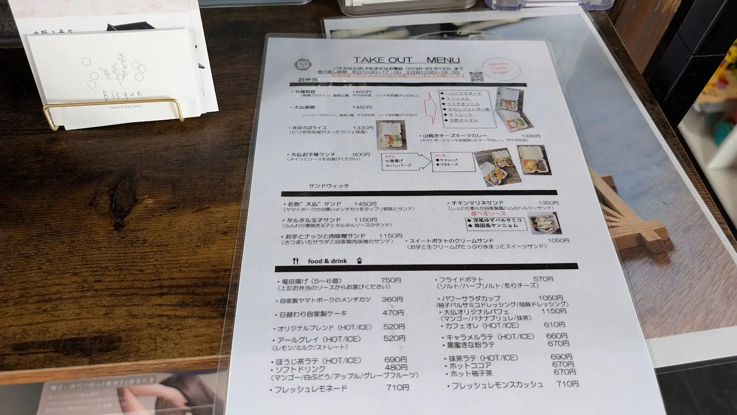 大仏カフェのテイクアウトメニュー表。お弁当、サンドウィッチ、サイドメニュー、ドリンクなどの価格と内容が記載されている