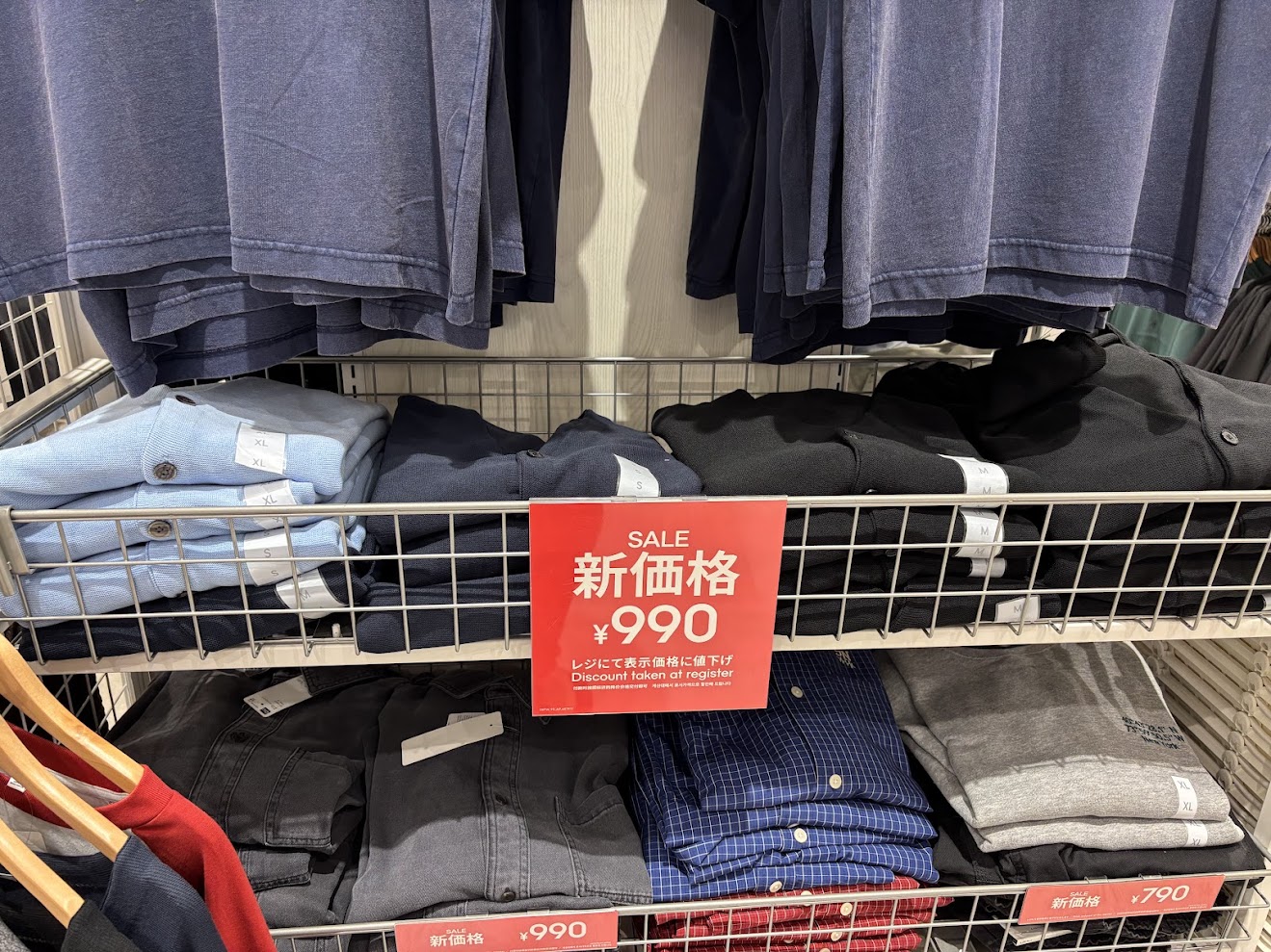 イオンモール橿原店GUの棚に陳列された990円のセール商品。赤色のプライスカードが掲示されている様子。