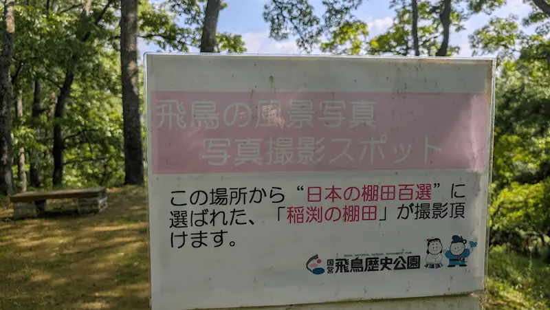 「日本の棚田百選」に選ばれた稲渕棚田が撮影できることを示す、飛鳥歴史公園の写真撮影スポット案内看板。