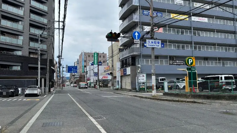 橿原市内の交差点から明日香・吉野方面へ続く道路。案内標識や周辺の街並み、駐車場の様子