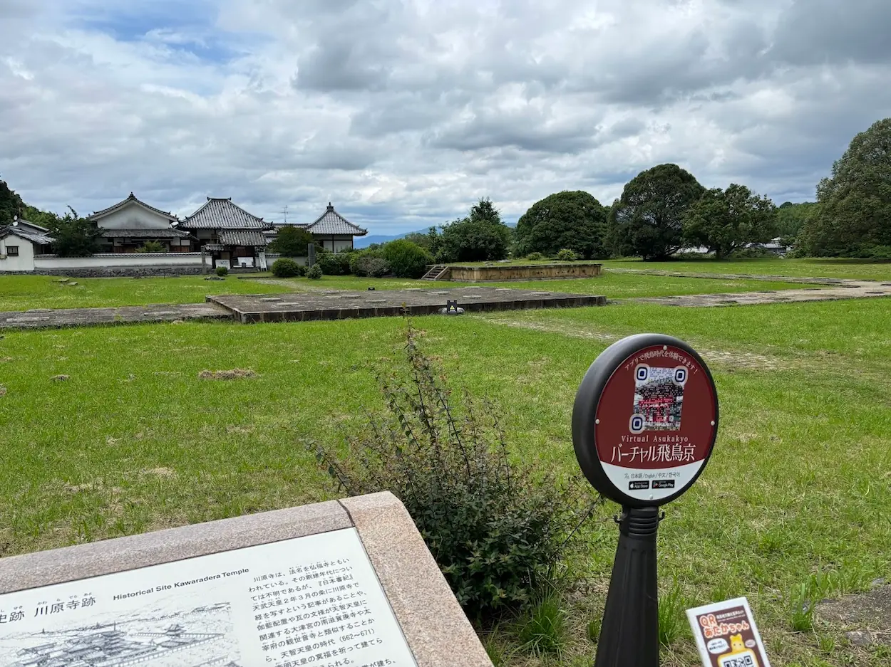 明日香村にある川原寺跡の広々とした境内と、飛鳥時代を体験できるARアプリの案内看板