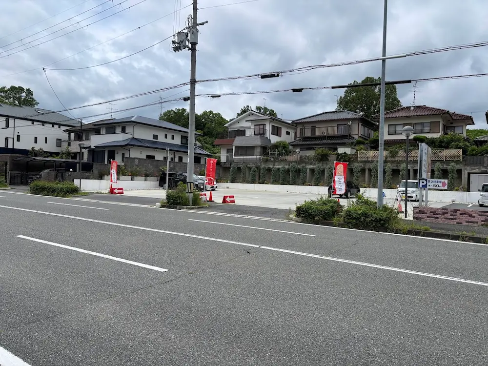 広陵町のパン屋「スペイン石窯パン GRECO」の店舗前にある広々とした駐車場と入口の様子