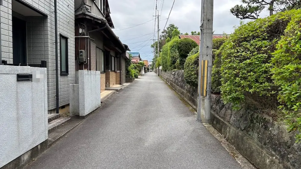 久米寺周辺の狭い生活道路。住宅が並び、植栽が彩る、車での通行には慎重さが求められる静かな道
