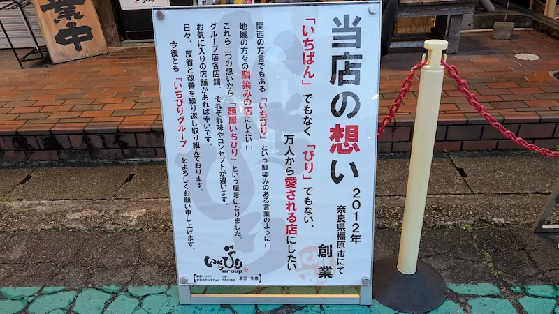 「麺屋いちびり」の店頭に設置された、店名の由来と想いが記された案内看板