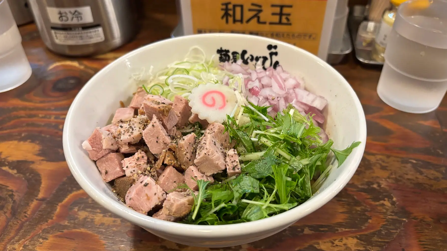 麺屋いちびりで提供される、角切りチャーシュー、刻み玉ねぎ、水菜が乗った彩り豊かなまぜそば
