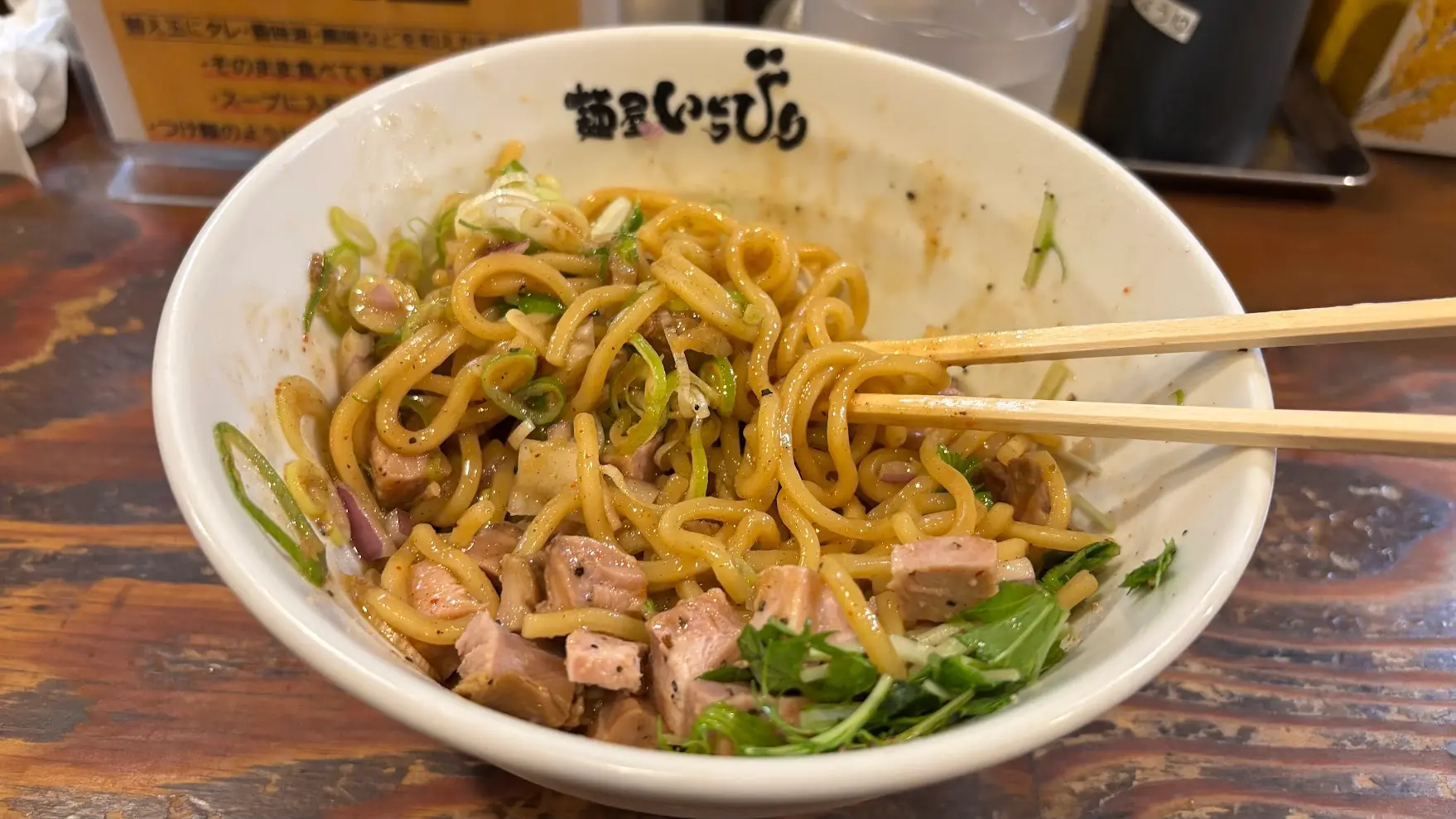 麺屋いちびりのまぜそばをよく混ぜた後の様子。タレが絡んだ太麺と角切りチャーシュー、薬味が一体となっている