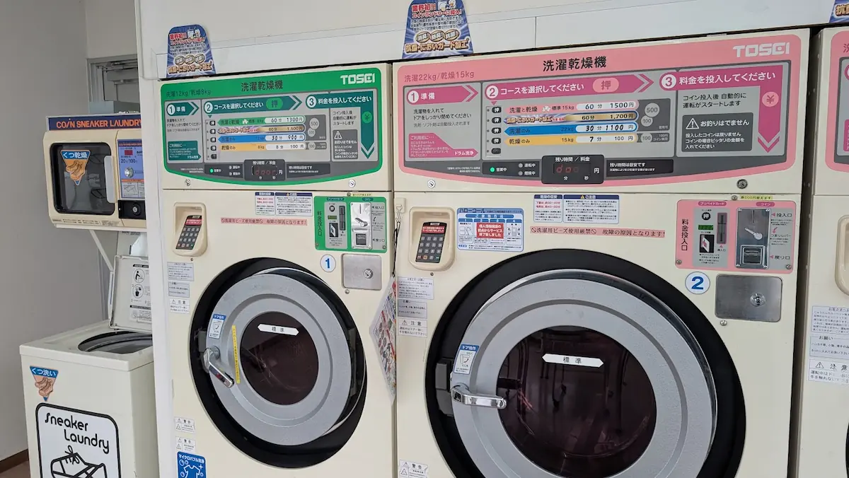 ノムラクリーニングの店内に並ぶ洗濯乾燥機。「抗菌においガード加工」コースが選択できる操作パネルの様子