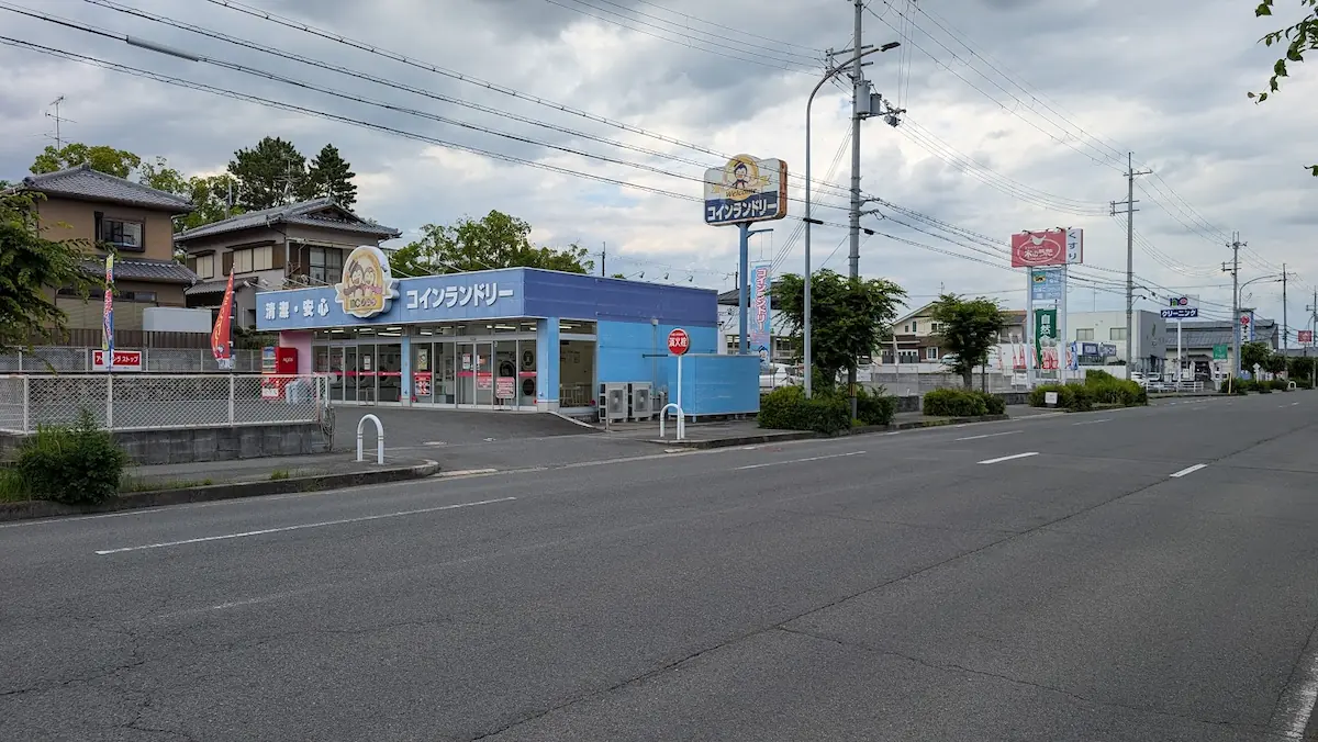 香芝市真美ヶ丘にあるノムラクリーニングのコインランドリー。青を基調とした店舗外観と、大きく掲げられたコインランドリーの看板