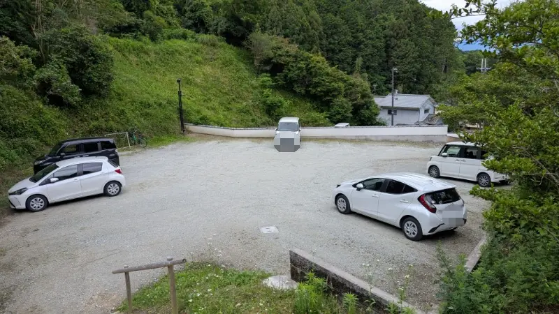 岡寺近くの無料第一駐車場の様子。砂利敷きの広いスペースに数台の乗用車が駐車されている