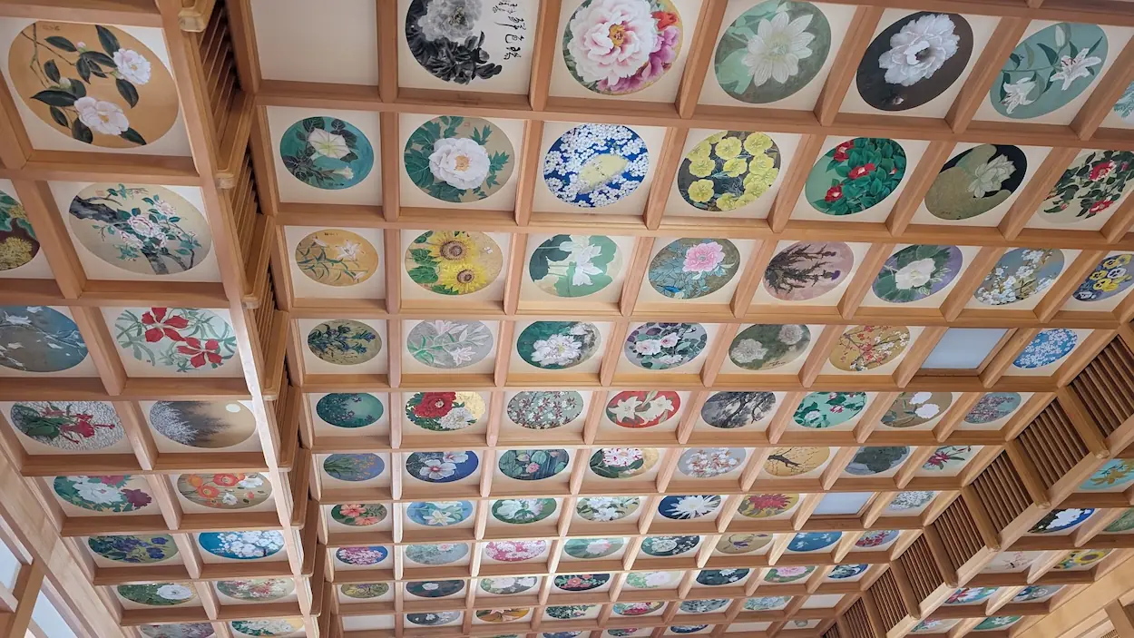 橘寺の本堂で見られる、色鮮やかな花の絵が数多く描かれた格天井の様子