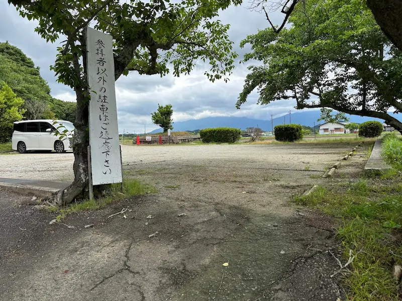 橘寺の駐車場入り口付近に設置された「参拝者以外の駐車はご遠慮ください」と書かれた看板と駐車スペースの風景