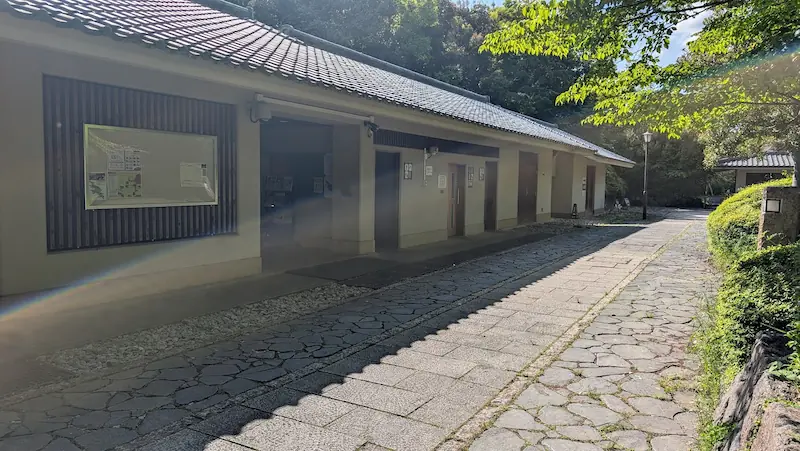 高松塚古墳第一駐車場にある休憩所と公衆トイレ。石畳の通路沿いに整備された施設の外観