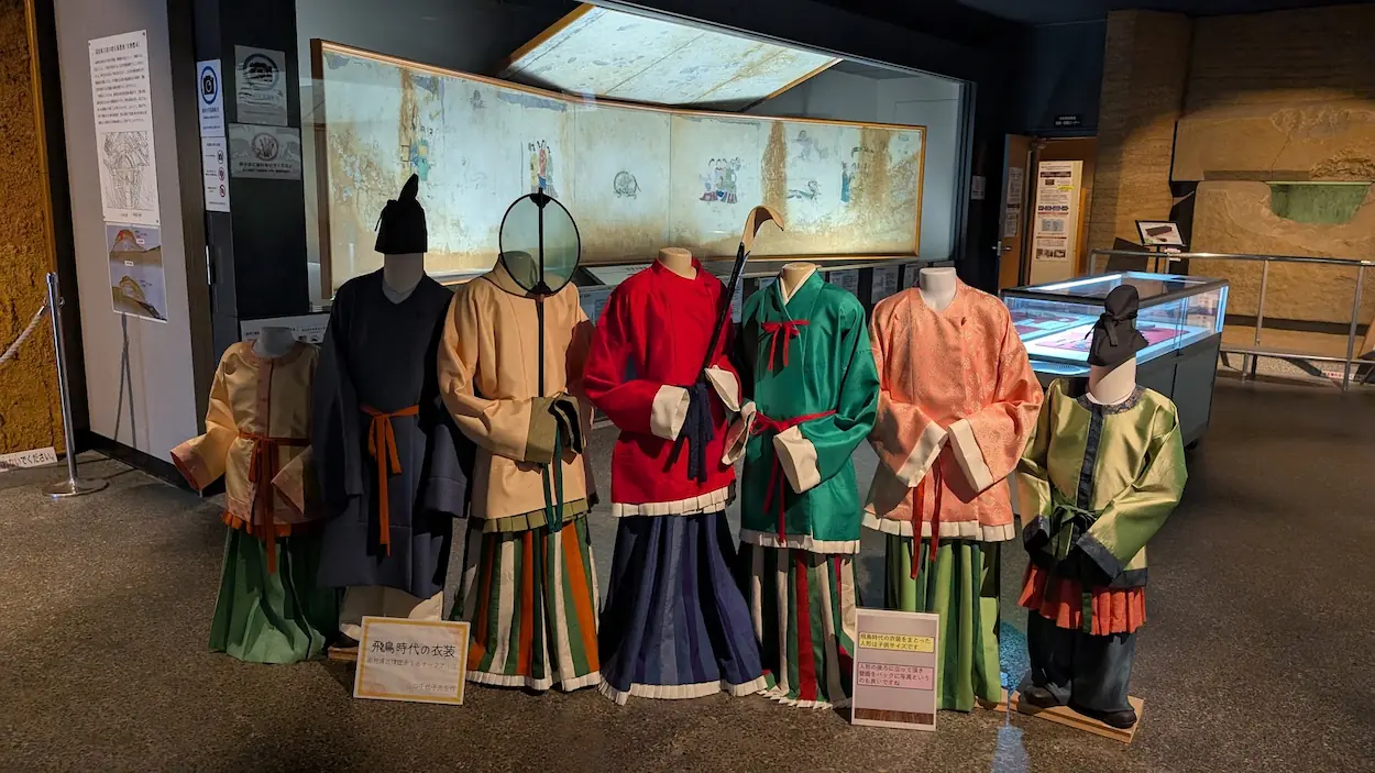 高松塚壁画館内に展示された、飛鳥時代の装束を再現した色鮮やかな衣装の人形たち