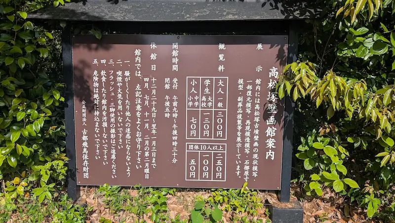 高松塚壁画館の観覧料、開館時間、休館日、および館内での注意事項が記載された案内板