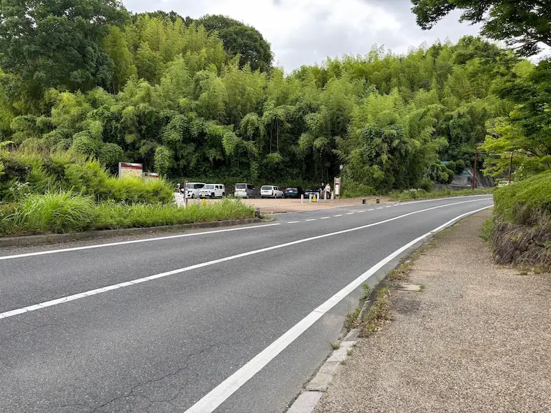 明日香村の高松塚古墳第一駐車場へ続く道路と入り口の様子。周囲は豊かな緑に囲まれている
