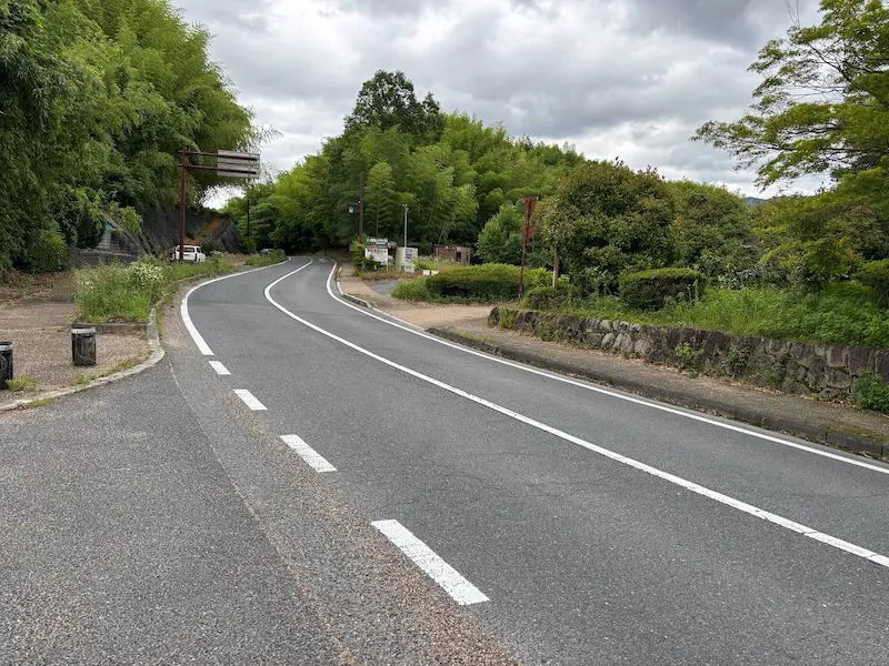 高松塚古墳第二駐車場への入り口付近。緑に囲まれた緩やかなカーブを描く県道の様子