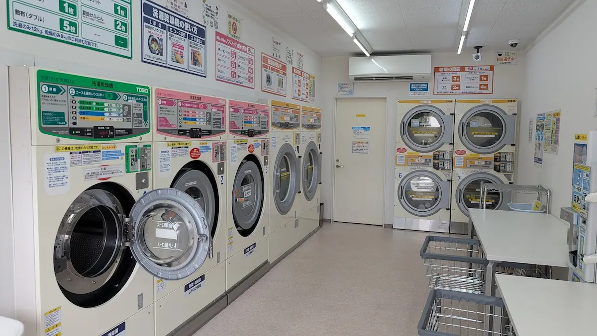 広陵町のコインランドリー「ウォッシュプラント」の店内。洗濯乾燥機が整然と並び、利用方法を説明する丁寧なポスターが壁面に掲示されている