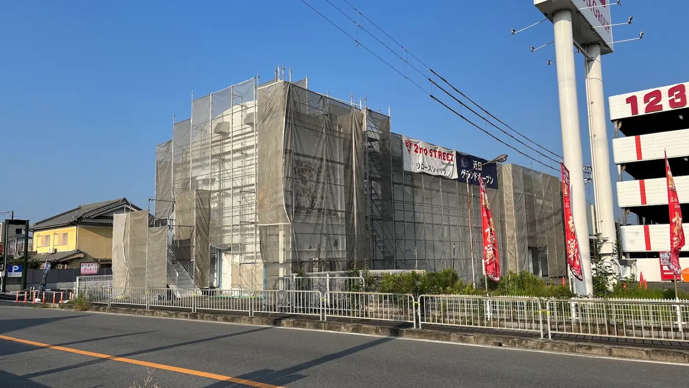工事用の足場と防風ネットで覆われた、改装中の2nd STREET（セカンドストリート）の建物の様子。外壁に「近日グランドオープン」の横断幕が掲げられている。