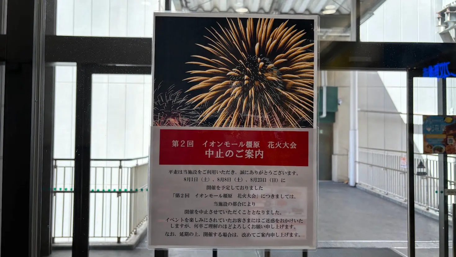 花火の写真と「第2回 イオンモール橿原 花火大会中止のご案内」の赤色の見出し、および詳細な開催中止の理由が記載された貼り紙全体の様子。