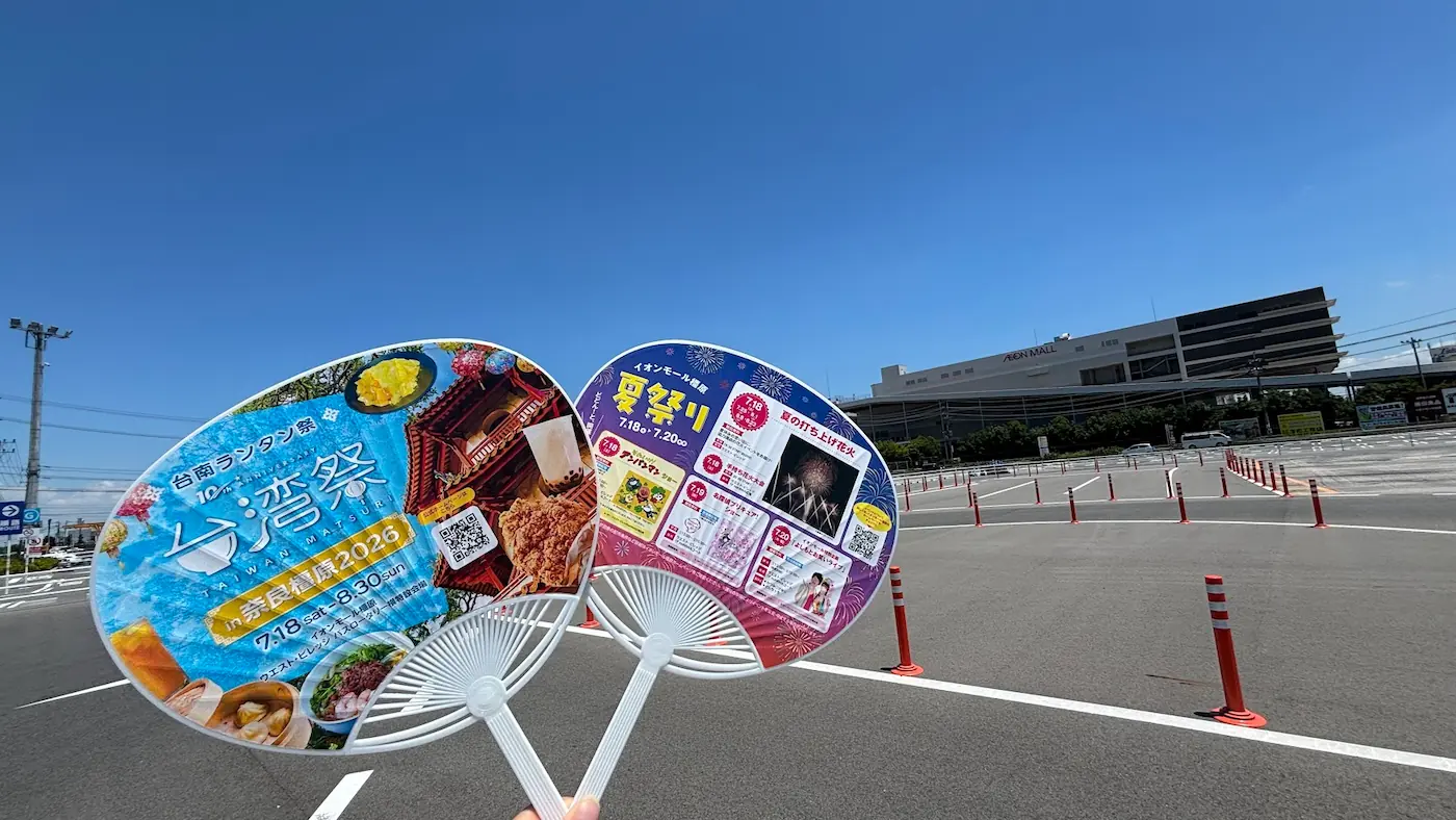イオンモール橿原ウエストビレッジのバス停側駐車場。手前には「台南ランタン祭 台湾祭」と「イオンモール橿原 夏祭り」のイベント告知うちわが写っている