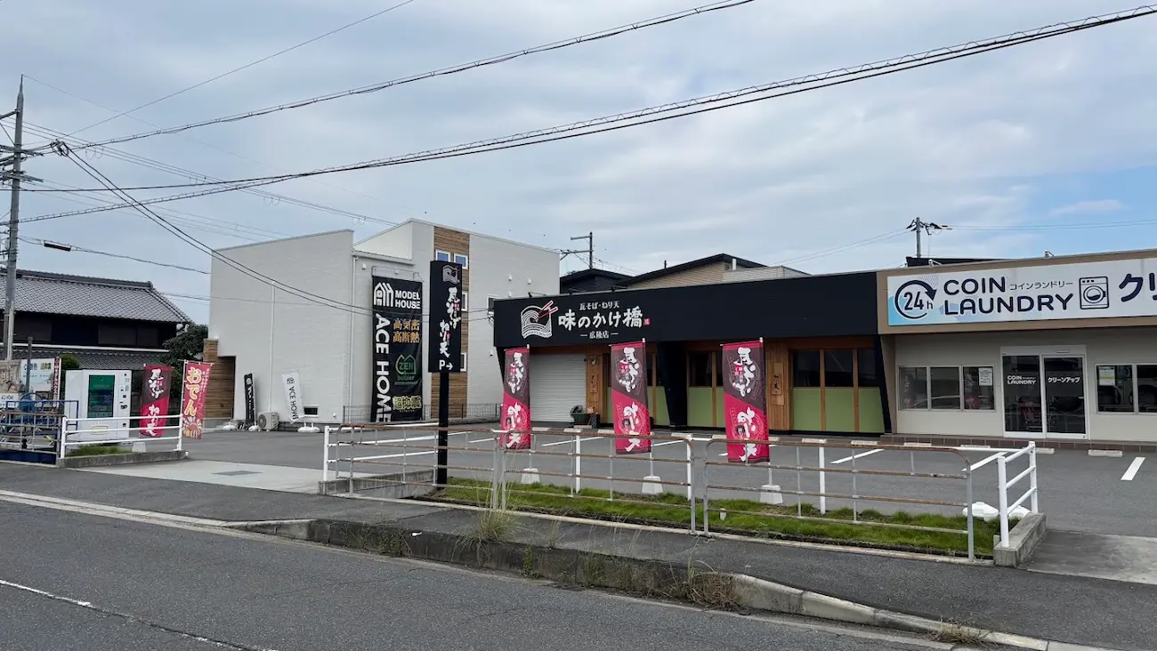 瓦そば専門店「味のかけ橋 広陵店」と、隣接するコインランドリーが並ぶ敷地の様子。駐車場を共有しており、両店舗の入り口が見える