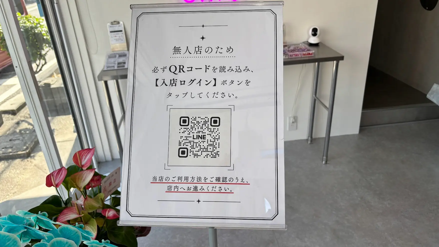 「BRACELET LAB.」の店内に置かれた案内板。無人店のため「必ずQRコードを読み込み、入店ログインボタンをタップしてください」と記載され、中央にLINEのQRコードが掲示されている様子。