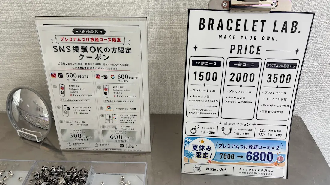 「BRACELET LAB.」の料金システムが記載された案内板。学割コース、一般コース、プレミアムつけ放題コースの価格や内容、およびSNS投稿でお得になるクーポン案内が並んでいる様子。