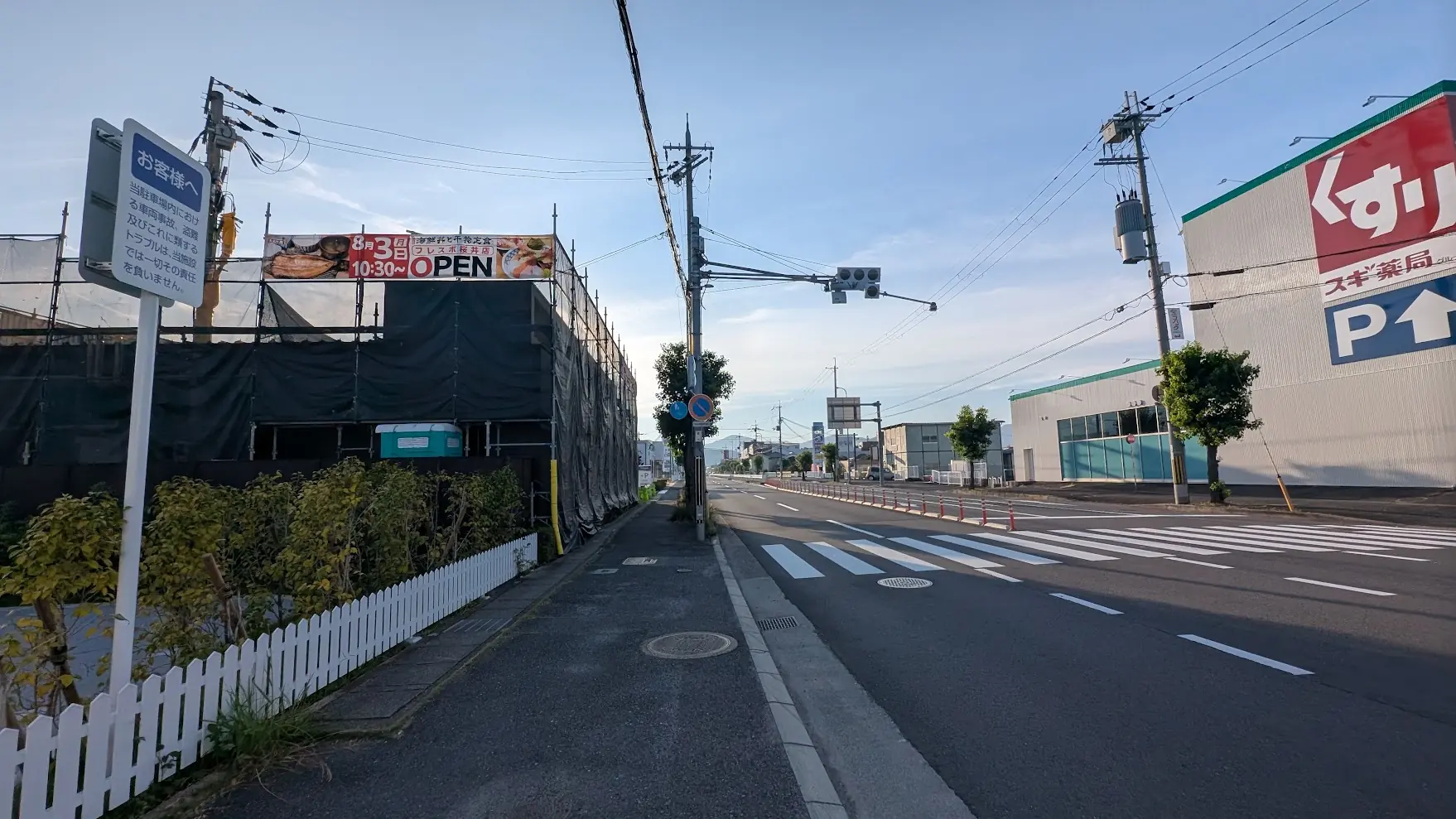 桜井方面を望む景色。工事中の「大起水産 海鮮丼と干物定食専門店」と隣接する「スギ薬局」があり、奥にはイオンや西松屋の看板が見える、周辺環境が分かる様子