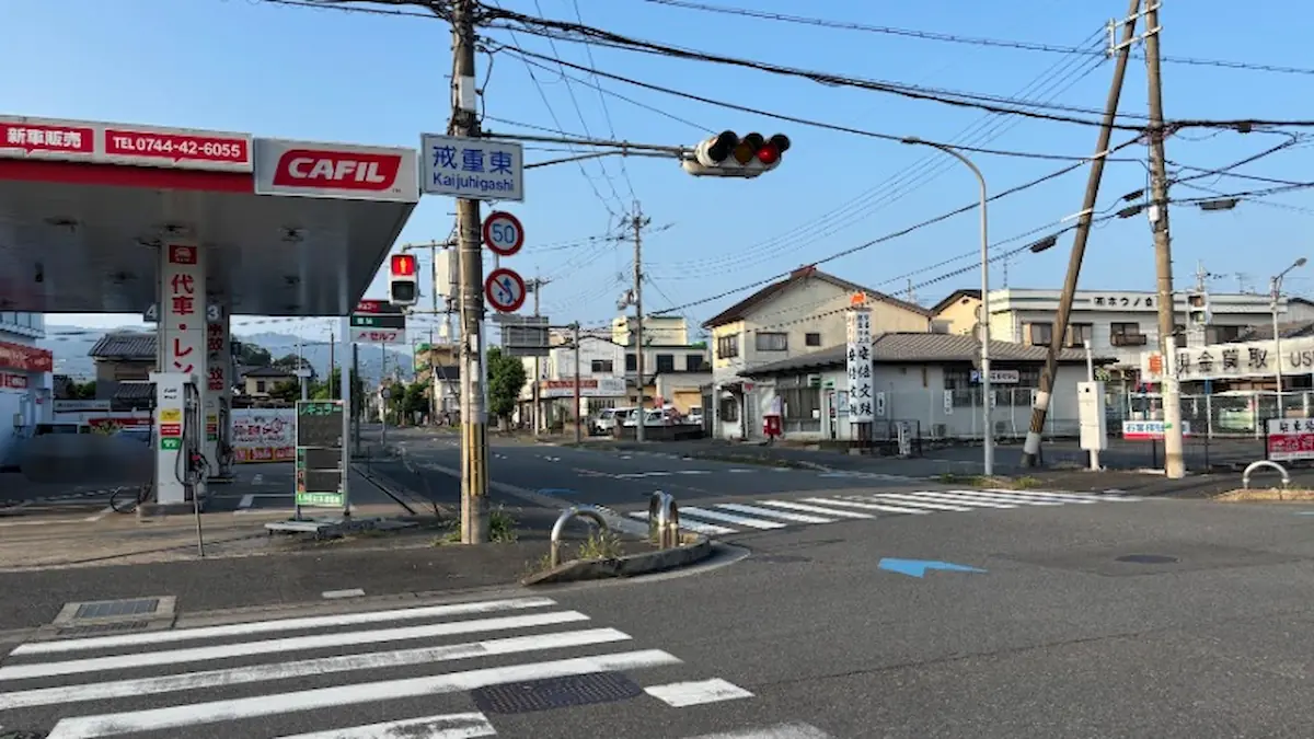 青空の下の「戒重東」交差点。左手にはCAFIL（ガソリンスタンド）、周囲には横断歩道や周辺の建物が写っている