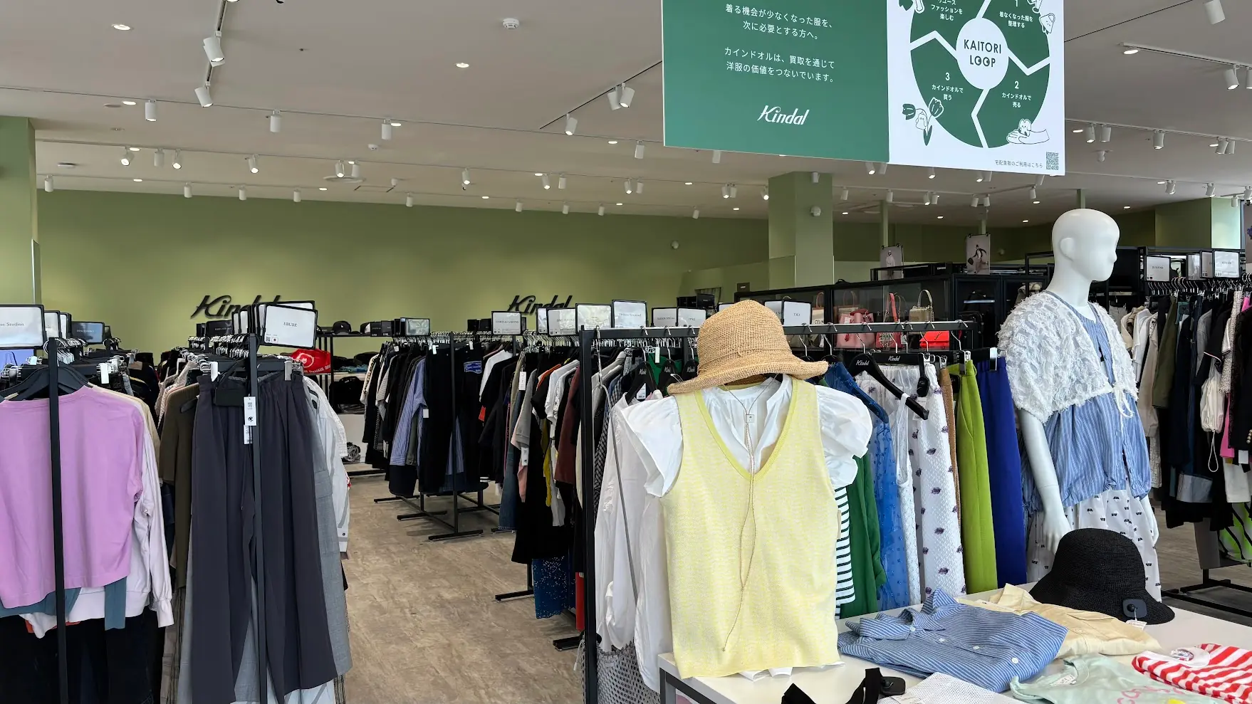 イオンモール橿原「カインドオル」の店内。ブランド古着が整然と並び、ディスプレイも洗練された明るい空間。買取サイクルの案内パネルも見える