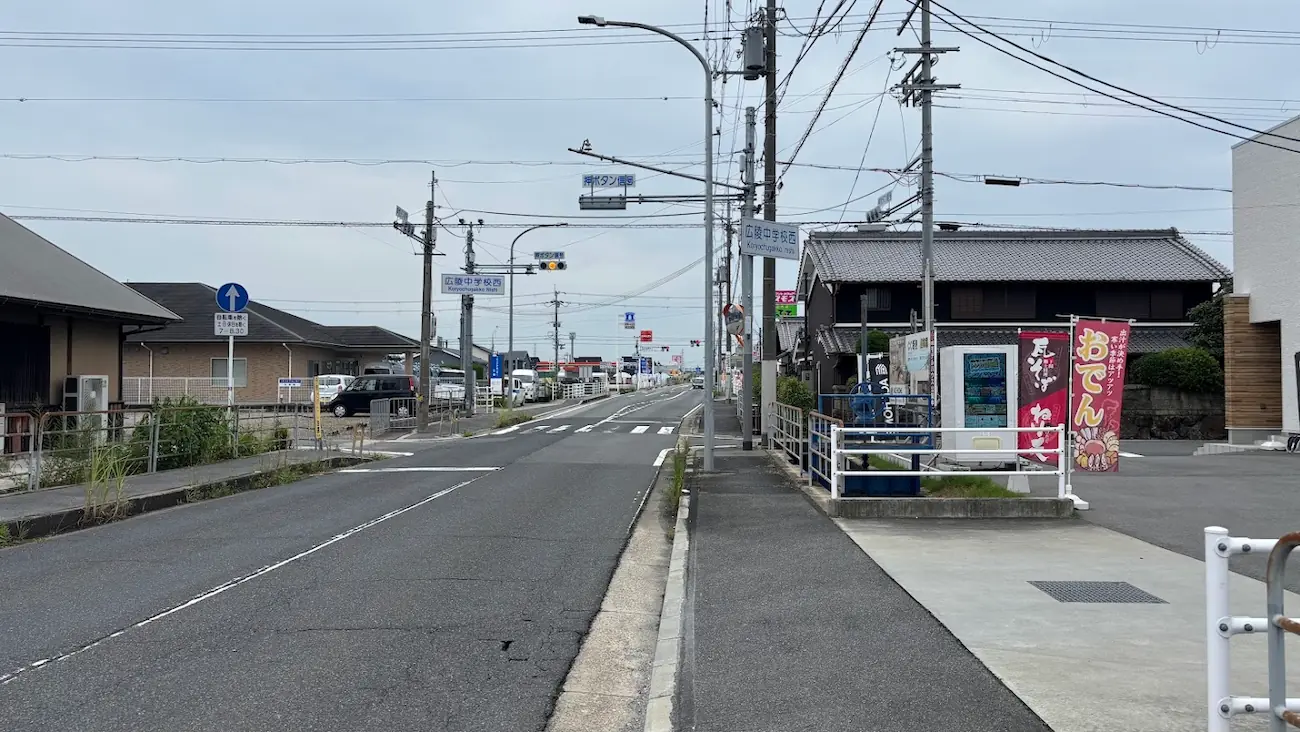 広陵中学校西交差点から高田方面を望む道。交差点には「おでん」の赤い旗や、先ほど話題になったトレカ自販機も確認できる