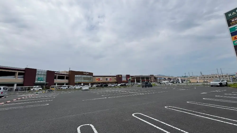 広々とした駐車場越しに見る、ラスパ西大和の全景。MEGAドン・キホーテやニトリなど、主要店舗のサインが見える