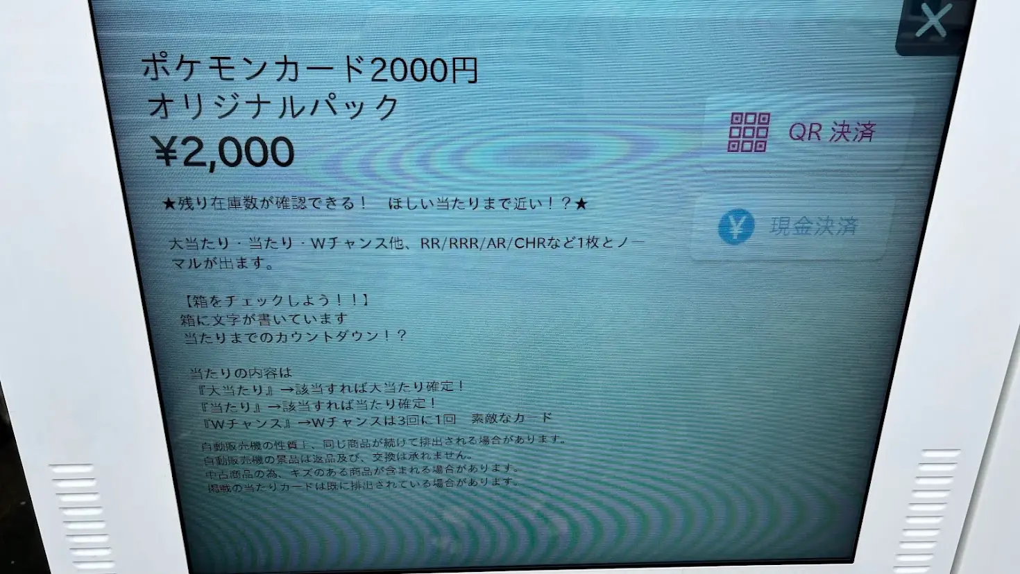 ポケモンカードゲーム自販機の操作画面。QR決済・現金決済の選択ボタン、および「当たり」や「Wチャンス」の仕組み、利用上の注意点が記載されている